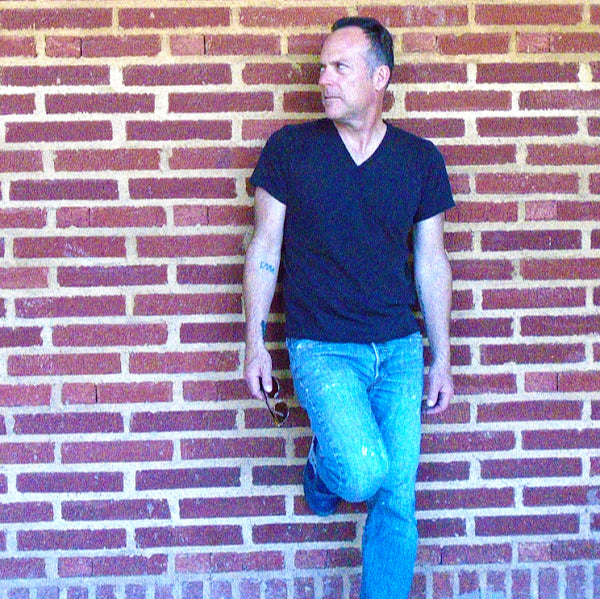 Photo of Michael Faeth standing in front of a brick wall.