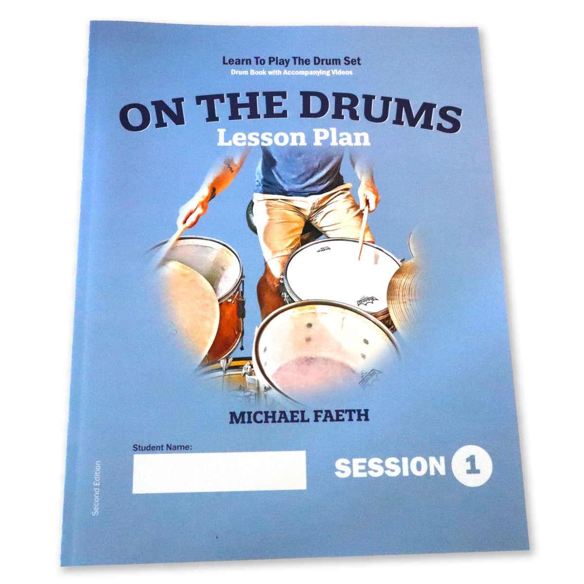 Book cover of the drum book On The Drums Lesson Plan, Session 1. Learn to play the drum set, drum book with accompanying videos. Shows a picture of a drummer at a drum set.